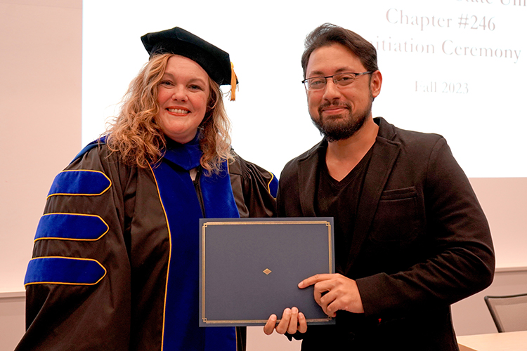 MTSU Associate Dean of the College of Graduate Studies Amy Harris, left, presents the Phi Kappa Phi initiation certificate to Adel Mahfooz, a computer science major, at the Phi Kappa Phi fall induction ceremony Oct. 20, 2023, at Middle Tennessee State University. (MTSU photo by Robin E. Lee)