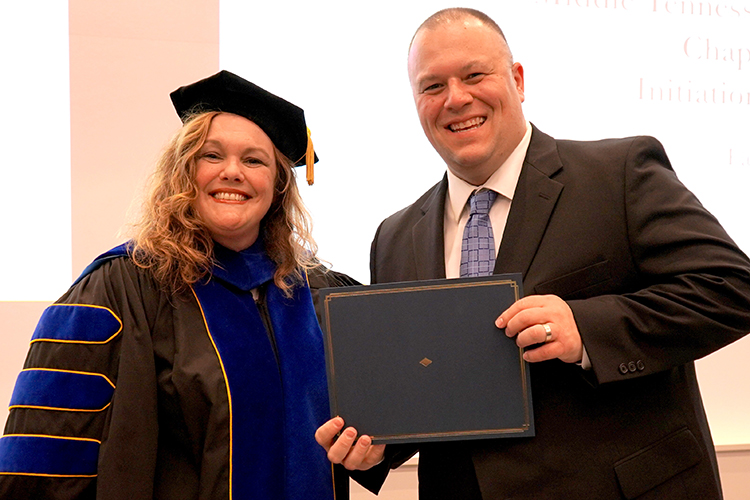 MTSU Associate Dean of the College of Graduate Studies Amy Harris, left, presents the Phi Kappa Phi initiation certificate to Chad Allen, an aeronautical science major, at the Phi Kappa Phi fall induction ceremony Oct. 20, 2023, at Middle Tennessee State University. ((MTSU photo by Robin E. Lee)