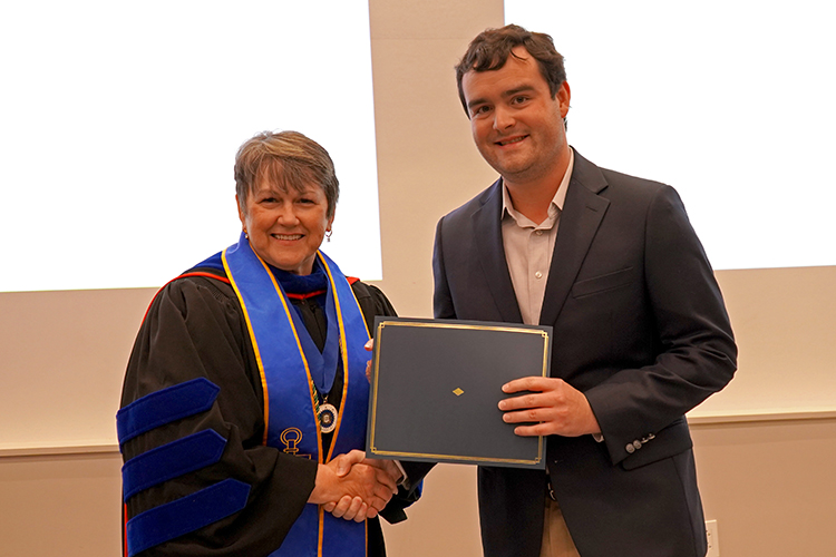 MTSU Jones College of Business Dean Joyce Heames, left, presents the Phi Kappa Phi initiation certificate to Greyson Fann, a business administration major, at the Phi Kappa Phi fall induction ceremony Oct. 20, 2023, at Middle Tennessee State University. (MTSU photo by Robin E. Lee)