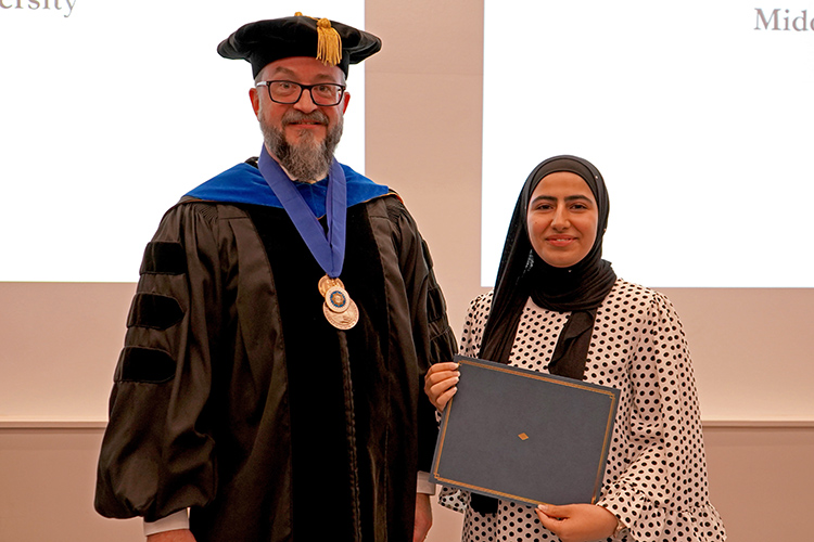 MTSU Honors College Associate Dean Philip Phillips, left, presents the Phi Kappa Phi initiation certificate to Malak Abdelrahman, a biochemistry major, at the Phi Kappa Phi fall induction ceremony Oct. 20, 2023, at Middle Tennessee State University. (MTSU photo by Robin E. Lee)