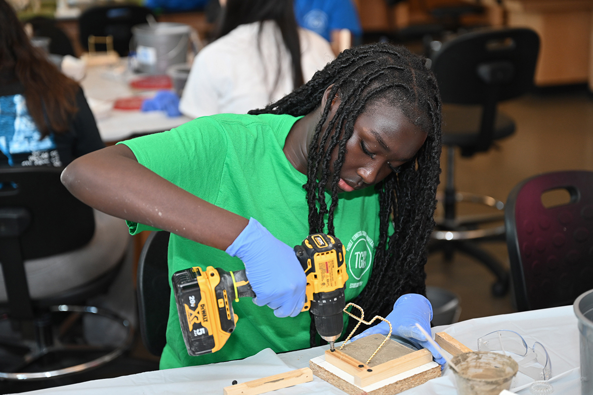 A middle school student uses a drill while completing her concrete coaster she made recently using with materials provided by the Middle Tennessee State University School of Concrete and Construction Management during the during the annual Tennessee Girls in STEM Conference at MTSU Saturday, Sept. 30. (MTSU photo by James Cessna)