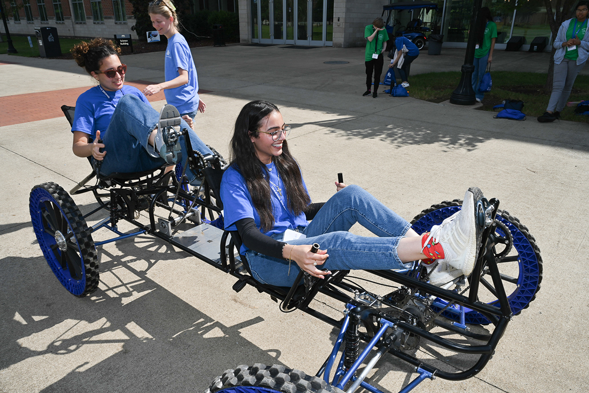 Girls navigate a lunar rover on the sidewalk near the Middle Tennessee State University Science Building Saturday, Sept. 30, as Lily Hardin of Nashville, Tenn., an MTSU graduate student with the Engineering Technology Experimental Vehicles Program, assists. (MTSU photo by James Cessna)