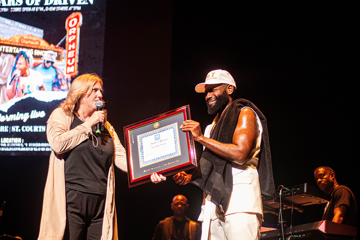 Beverly Keel, left, dean of the College of Media and Entertainment at Middle Tennessee State University, presents a framed honorary professorship certificate to alumnus and independent hip-hop artist Tyrone “Tyke T” Stroble on Sept. 17 during a break in his special concert at the Orpheum Theatre in Memphis, Tenn. (Courtesy of Amiya Samaar)