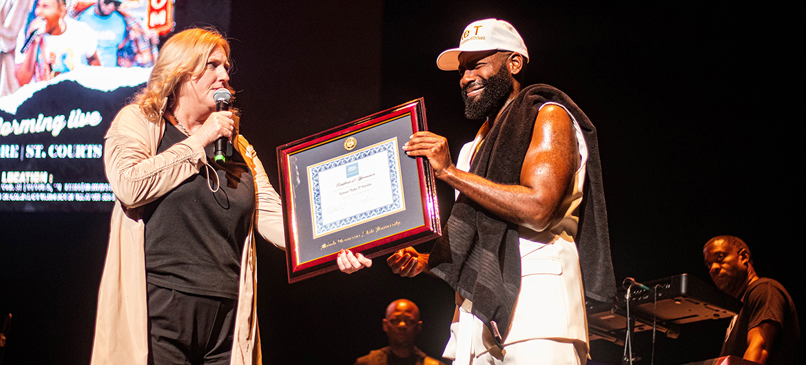 Beverly Keel, left, dean of the College of Media and Entertainment at Middle Tennessee State University, presents a framed honorary professorship certificate to alumnus and independent hip-hop artist Tyrone “Tyke T” Stroble on Sept. 17 during a break in his special concert at the Orpheum Theatre in Memphis, Tenn. (Courtesy of Amiya Samaar)