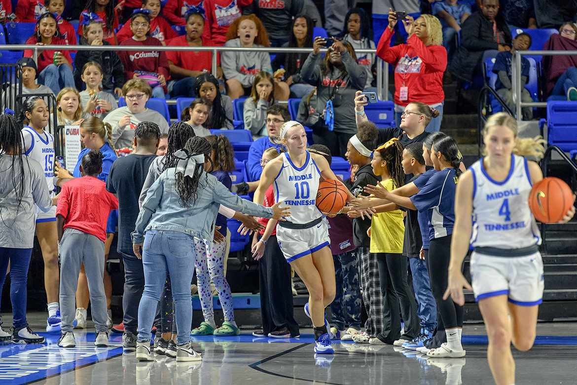 A group of Murfreesboro City Schools students welcomes No. 10 Jalynn Gregory to the court at the start of the 10th annual Education Day game Nov. 9, 2023, at Murphy Center on the Middle Tennessee State University campus. Gregory, who scored 15 points, and the Lady Raiders women’s basketball team defeated the Florida A&M Rattlers by a score of 93-48. (MTSU photo by J. Intintoli)