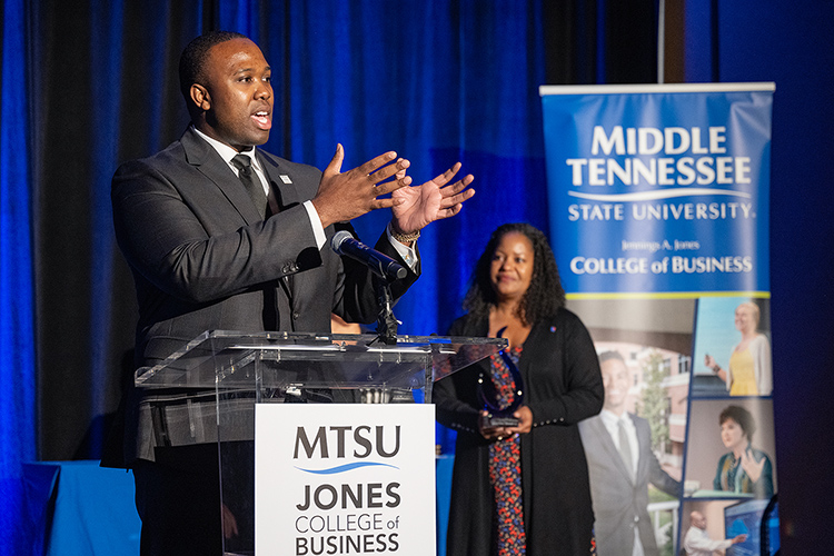 Middle Tennessee State University alumnus Charles Avent Jr. gives remarks as recipient of the 2023 Young Professional of the Year Award from the Jones College of Business during a special ceremony Oct. 19, 2023, at Embassy Suites in Murfreesboro, Tenn. In the background is Yolanda Greene, Rutherford County community bank president for event sponsor First Horizon Bank. (MTSU photo by Cat Curtis Murphy)