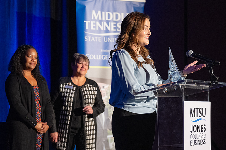 Middle Tennessee State University alumna Jami Averwater gives remarks as recipient of the 2023 Jones College Exemplar Award from the Jones College of Business during a special ceremony Oct. 19, 2023, at Embassy Suites in Murfreesboro, Tenn. In the background are Yolanda Greene, left, Rutherford County community bank president for event sponsor First Horizon Bank, and Jones College Dean Joyce Heames. (MTSU photo by Cat Curtis Murphy)