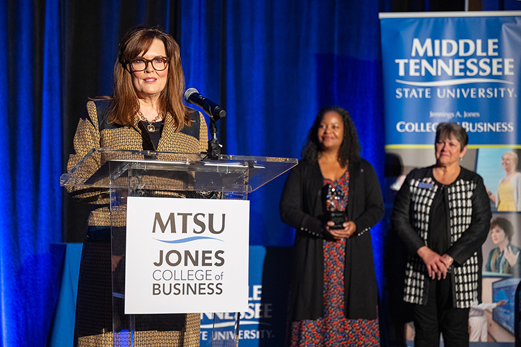 Middle Tennessee State University alumna Lisa Nix gives remarks as the 2023 recipient of the Joe M. Rodgers Spirit of America Award from the Jones College of Business during a special ceremony Oct. 19, 2023, at Embassy Suites in Murfreesboro, Tenn. In the background are Jones College Dean Joyce Heames, right, and Yolanda Greene, Rutherford County community bank president for event sponsor First Horizon Bank. (MTSU photo by Cat Curtis Murphy)