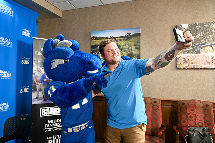 Barrett Firearms Manufacturing employee Franz Walkup, ATF compliance manager, grabs a selfie with MTSU mascot Lightning Monday, Nov. 6, following a signing ceremony at Barrett’s facility in Christiana, Tenn., formalizing a new partnership that began this fall that providing tuition assistance to eligible Barrett employees taking courses at Middle Tennessee State University. (MTSU photo by J. Intintoli)