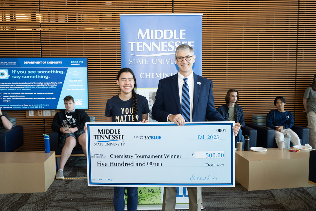 Sophie McAtee, left, of Brentwood, Tenn., a Ravenwood High School senior, receives the first-place prize — plus a $2,000 scholarship — from Greg Van Patten, dean of the Middle Tennessee State University College of Basic and Applied Sciences recently during the awards ceremony for the annual MTSU Chemistry Tournament. Forty-five high school students from around the region participated in the event, held in the MTSU Science Building. (MTSU photo by James Cessna)