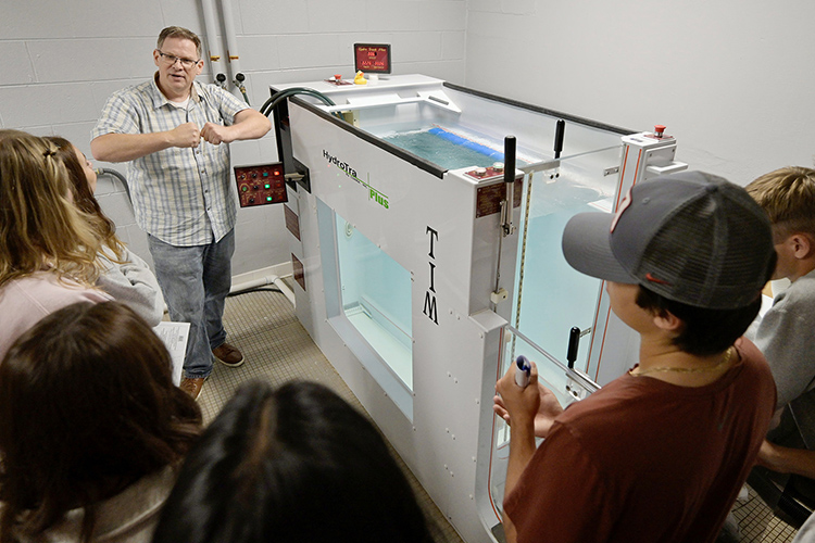 John Coons, professor of graduate studies in Exercise Science at Middle Tennessee State University, shows off the underwater treadmill to touring students from Williamson County high schools. (MTSU photo by Cat Curtis Murphy)
