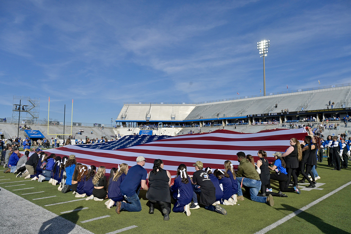 A group of Middle Tennessee State University students and others hold on to the large U.S. flag on the field in Floyd Stadium Saturday, Nov. 11, before the kickoff for the MTSU-FIU college football game. MTSU won the Conference USA college football game, 40-6. (MTSU photo by Andy Heidt)