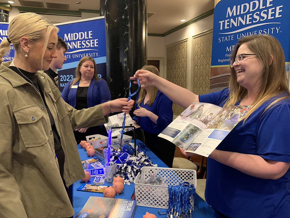 Ryleigh Brown, left, a senior at Dobyns-Bennett High School in Kingsport, Tenn., learns about scholarship opportunities and more and receives a lanyard from Meredith Wright, enrollment coordinator for the Middle Tennessee State University Admissions Office Oct. 24 during the university’s True Blue Tour recruiting event at the Carnegie Hotel in Johnson City, Tenn. (MTSU photo by Randy Weiler)