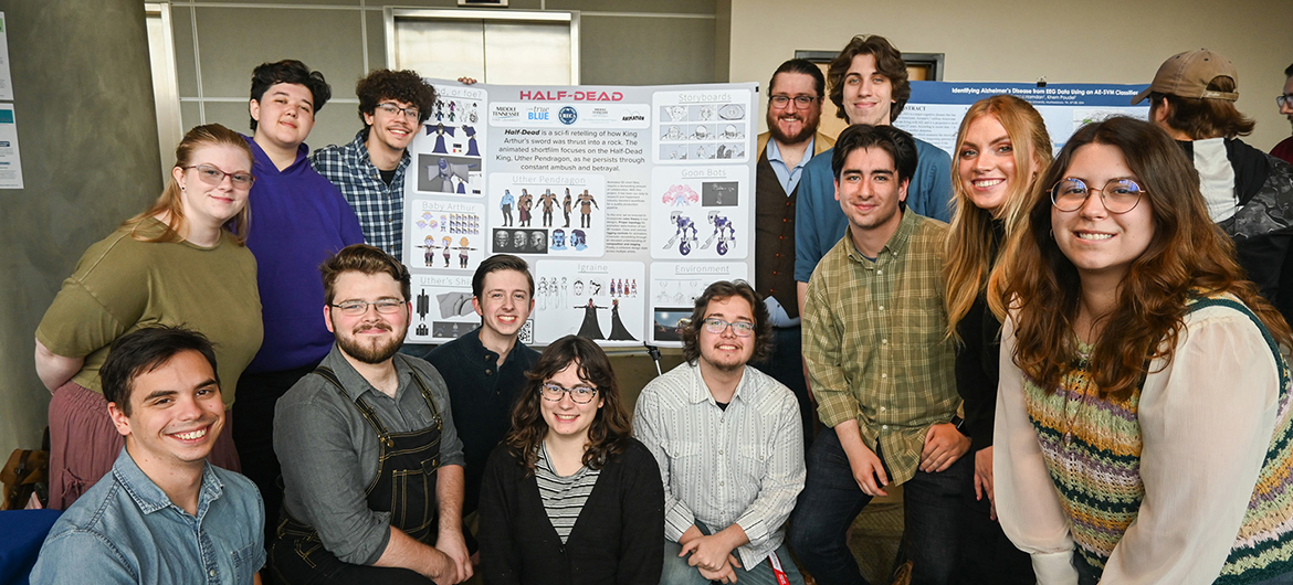 Middle Tennessee State University animation students and their professor pose with their animation project poster at the MTSU Undergraduate Research Center’s sixth annual Open House on Thursday, Nov. 9, at the Science Building on campus. Standing, from left, are Bailey Holland, Lance Harbour, Drew Lacey, animation professor Corey Reece, Seth Savage, Elvis Hertado, Natalie Rapier and Emma Gresham. Kneeling, from left, are Sean Kangas, Zachary Legaux, Andy Belcher, Audrey Roberts, and Josh Mahan. (MTSU photo by Stephanie Wagner)