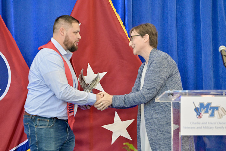 Laurie Witherow, interim vice provost for enrollment services at Middle Tennessee State University, presents business administration major Paul Schoenfeld the Veterans Leadership Award at the 27th Graduating Veterans Stole Ceremony held Thursday, Dec. 14, 2023, at Miller Education Center. (MTSU photo by Andy Heidt)