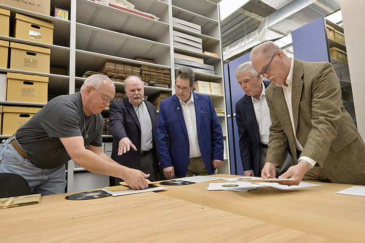 Martin Fisher, curator of Recorded Media Collections at the Center for Popular Music at Middle Tennessee State University, at left, shows some of the vinyl recordings to great-grandsons of Grand Ole Opry legend Uncle Dave Macon. Also pictured, starting second from left, are Mike Doubler, Paul Doubler, Bernie Doubler and John Doubler. The siblings were visiting the CPM Nov. 20, 2023, to present funding for a grant for scholars researching the life and legacy of Uncle Dave Macon. (MTSU photo by Andy Heidt)