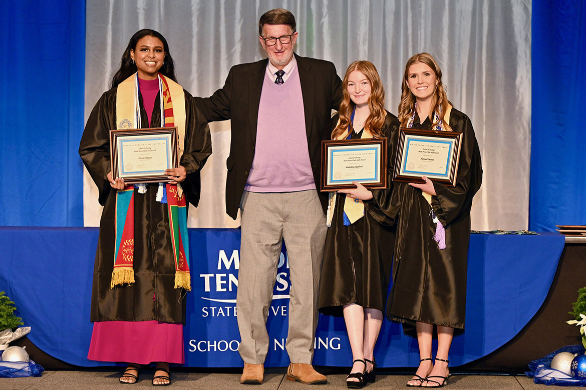 Middle Tennessee State University alumnus Clyde Hall, center, congratulates MTSU School of Nursing graduates Naomi Tekeste, far left, Madeleine Radford, second from right, and Hannah Moran, far right, who are winners of the Marie Potts/Clyde Hall Personal Achievement Award. The scholarship is given to students who exhibit need and perseverance, as voted on by their peers, and was awarded this semester to the three students during the pinning ceremony for graduating School of Nursing students on Dec. 15, 2023. (MTSU photo by James Cessna)