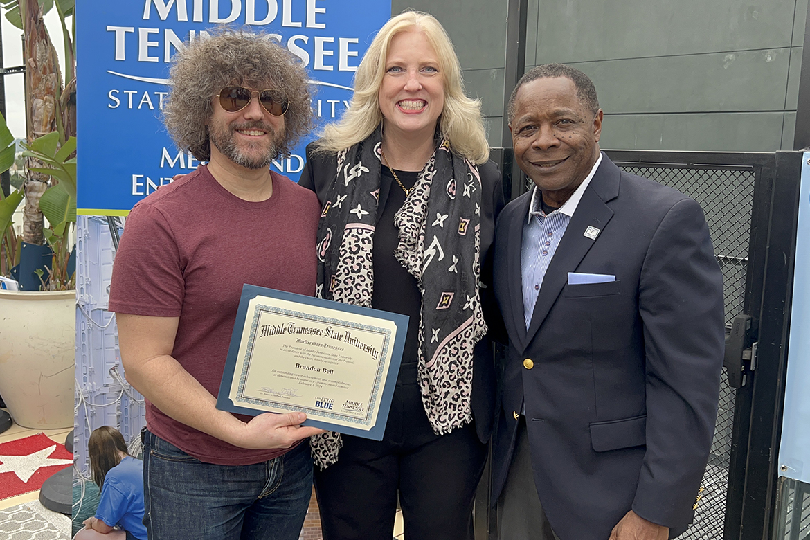 Two-time Grammy winner and 2024 multiple nominee Brandon Bell, left, a 2004 Recording Industry graduate of Middle Tennessee State University, holds the special certificate he received from MTSU College of Media and Entertainment Dean Beverly Keel, center, and MTSU President Sidney A. McPhee, right, at the university’s annual recognition and appreciation event for alumni nominees and other graduates Saturday, Feb. 3, 2023, at Mama Shelter Hotel rooftop spot in Los Angeles in advance of the 66th annual Grammy Awards. (MTSU photo by Andrew Oppmann)