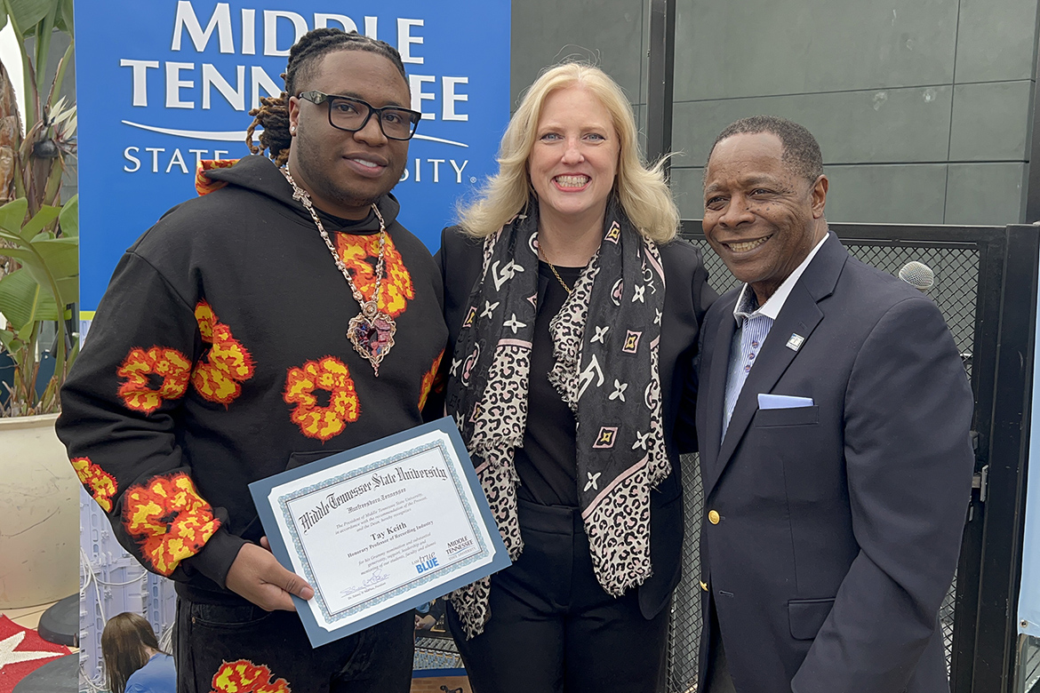 2024 Grammy Award nominee Brytavious “Tay Keith” Chambers, left, a 2018 graduate of Middle Tennessee State University, holds the special certificate he received from MTSU College of Media and Entertainment Dean Beverly Keel, center, and MTSU President Sidney A. McPhee, right, at the university’s annual recognition and appreciation event for alumni nominees and other graduates Saturday, Feb. 3, 2023, at Mama Shelter Hotel rooftop spot in Los Angeles in advance of the 66th annual Grammy Awards. (MTSU photo by Andrew Oppmann)