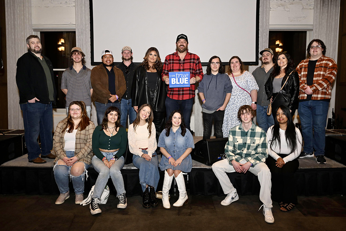 Holding an “I am True Blue” sign, Middle Tennessee State University alumnus and country music superstar Chris Young, center, and rising country artist Jaelee Roberts, center left, take a photo with a group of MTSU Recording Industry program students during a meet-and-greet Feb. 7 at Blake Shelton’s Ole Red restaurant and live music venue in downtown Nashville, Tenn. Both performed at a special Music in the City event hosted by Nashville Lifestyles magazine. (MTSU photo by James Cessna)