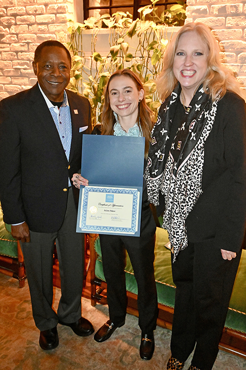 2019 English graduate of Middle Tennessee State University Julien Baker, center, a 2024 multiple Grammy Award nominee as a member of indie supergroup boygenius, holds the honorary professorship in recording industry certificate she received from MTSU President Sidney A. McPhee, left, and MTSU College of Media and Entertainment Dean Beverly Keel, right, in Los Angeles in advance of the 66th annual Grammy Awards. (MTSU photo by Andrew Oppmann)