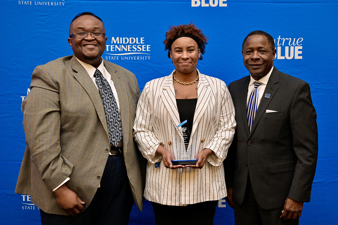 Middle Tennessee State University President Sidney A. McPhee, right, presents "unsung hero" Award for Contribution to Black Arts honoring the late music teacher Johnie Payton to her former student, Gerald Patton, left, and niece Bryanna Payton, both accepting on behalf of the educator who died in 2022, at the 2024 Unity Luncheon held Thursday, Feb. 8, in the Student Union Ballroom. (MTSU photo by Andy Heidt)