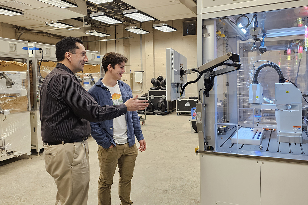 Middle Tennessee State University junior mechatronics engineering major Samuel Apigian of Murfreesboro, Tenn., right, and Engineering Technology lecturer Antonio Saavedra watch robotics equipment at work inside a Voorhees Engineering Technology laboratory. Apigian is heading to Germany this summer after being awarded the highly competitive Deutscher Akademischer Austauschdienst Research Internship in Science and Engineering, better known as the DAAD RISE scholarship. Apigian will be interning at Technische Universität Dresden. (MTSU photo by Robin E. Lee)