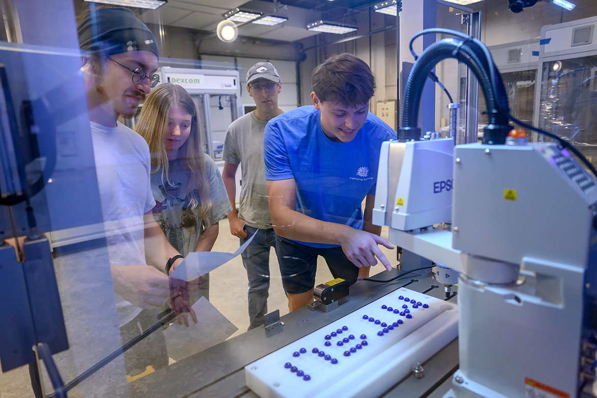Middle Tennessee State University mechatronics engineering student Daniel Wetter, right, of Murfreesboro, Tenn., checks out the efficiency of new robotics equipment students will be able to utilize starting this fall. Also taking in the opportunity to view the equipment during the fall 2023 semester were, from left, Jackson Clemons of Knoxville, Tenn., graduate assistant Lily Hardin of Nashville, Tenn., and Jason Huffman of Powder Springs, Ga. The equipment, valued at nearly $920,000, was a gift from Dexcom. Fellow partner Automation Nth committed an additional $100,000 in equipment and services to upgrade the units. (MTSU photo by J. Intintoli)