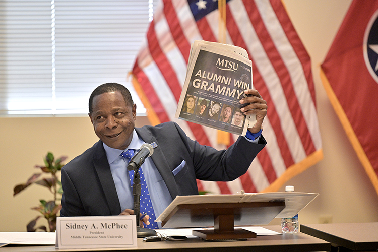 Middle Tennessee State University President Sidney A. McPhee holds up a copy of an advertisement touting alumni who won Grammy Awards this year while giving his president’s report at the MTSU Board of Trustees quarterly meeting held Tuesday, March 19, at the Miller Education Center on Bell Street in Murfreesboro, Tenn. (MTSU photo by J. Intintoli)