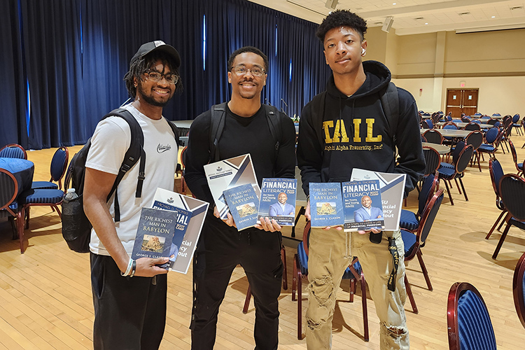 From left, Middle Tennessee State University students Terrance Taylor, Tyree Brown and Jaylen Few hold a copy of a book and other materials from Michael “Bootcamp” Thomas following his keynote address for Middle Tennessee State University’s Financial Literacy Month on April 10 in the Tennessee Room of the James Union Building on the MTSU campus in Murfreesboro, Tenn. (MTSU photo by Jimmy Hart)
