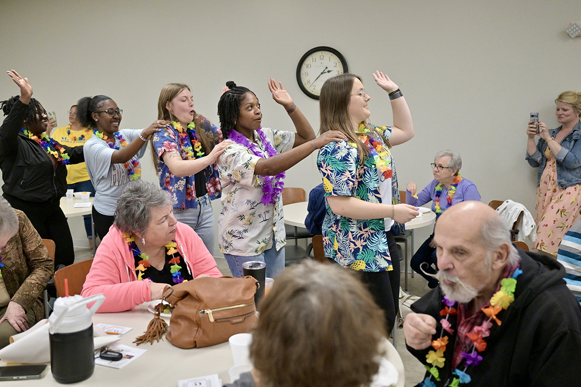 Students in the Aging Health and Development course at Middle Tennessee State University in Murfreesboro, Tenn., from left, Alexis Mason, Victoria Jennings, Katy Champion, Sydnee Washington and Kylie Calvert lead a dance train in the activity room of St. Clair Street Senior Center during a “cruise” party held as part of class on March 29, 2024. Each Friday during the semester, students taught by Human Development and Family Science lecturer Samantha Weir, seen at far right, plan and implement interactive games at St. Clair as well as Stones River Manor, also in Murfreesboro. (MTSU photo by J. Intintoli)