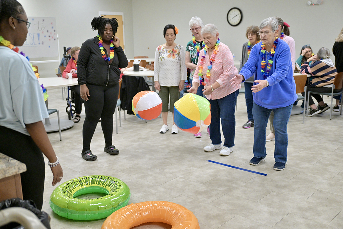 Victoria Jennings, left, and Alexis Mason, second from left, both students in the Aging Health and Development course at Middle Tennessee State University in Murfreesboro, Tenn., watch as members of St. Clair Street Senior Center in Murfreesboro toss inflatable beach balls into rings as part of a “cruise” party held as part of class on March 29, 2024. Each Friday during the semester, students in the class taught by Human Development and Family Science lecturer Samantha Weir plan and implement interactive games at St. Clair as well as Stones River Manor, also in Murfreesboro. (MTSU photo by J. Intintoli)