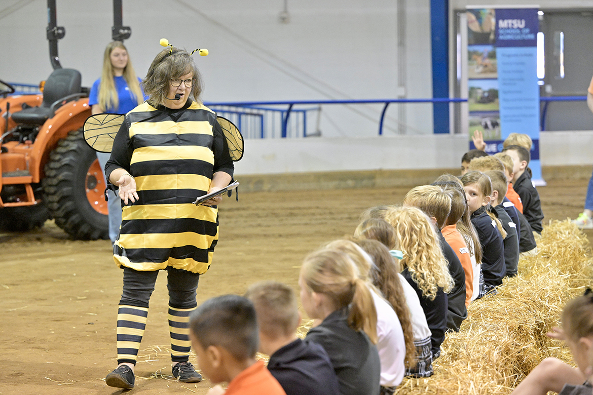 Dressed in a bee costume, retired Middle Tennessee State University School of Agriculture executive aide Debbie Strobel discusses bees and how they make honey with Middle Tennessee Christian School elementary students attending the annual School of Agriculture Ag Education Spring Fling on April 16 in the Tennessee Livestock Center on the MTSU campus in Murfreesboro, Tenn. (MTSU photo by Andy Heidt)