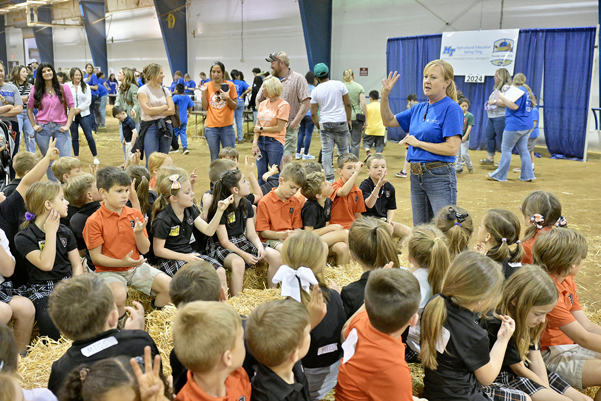 Middle Tennessee Christian School elementary students wait their turn to enter the Little Acres area featuring vegetables Tuesday, April 16, in the Middle Tennessee State University Tennessee Livestock Center on Greenland Drive in Murfreesboro, Tenn. Alanna Vaught, right, event director and School of Agriculture lecturer, has them perform a counting exercise while they wait. (MTSU photo by Andy Heidt)