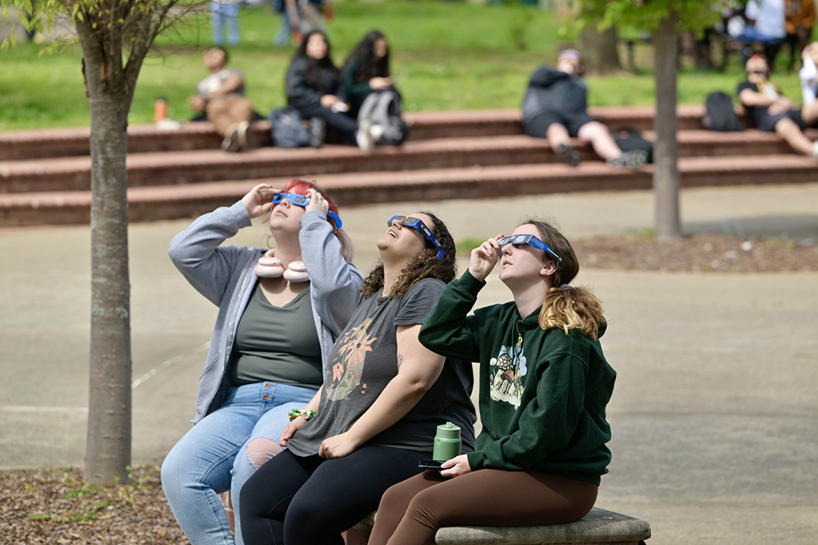 People sit on benches in the Middle Tennessee State University Quad area on the MTSU campus to view the solar eclipse that brought 93% totality to the Murfreesboro, Tenn., area. About 200 people viewed the eclipse in the quad on Monday, April 8.  (MTSU photo by Andy Heidt)