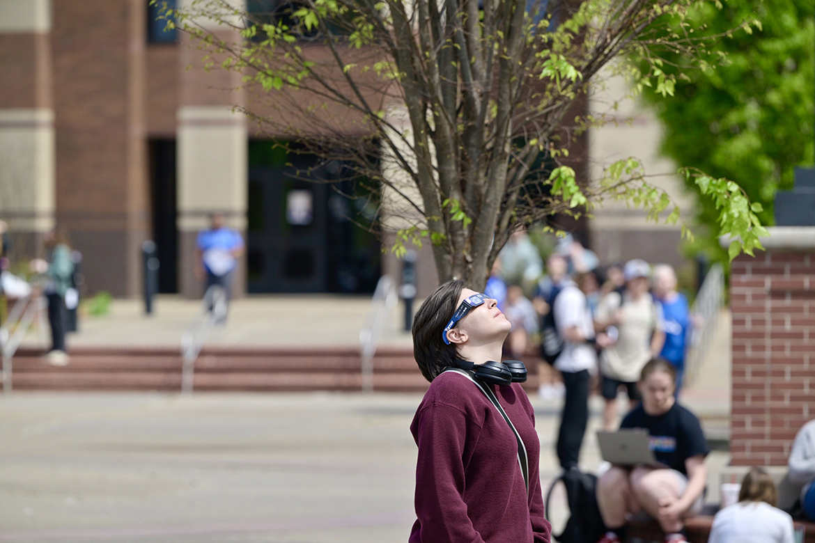 Using Middle Tennessee State University Physics and Astronomy eclipse glasses, an MTSU student views the solar eclipse from the Quad area Monday, April 8, on the MTSU campus in Murfreesboro, Tenn. An estimated 650 eclipse glasses were handed out for the event. (MTSU photo by Andy Heidt)