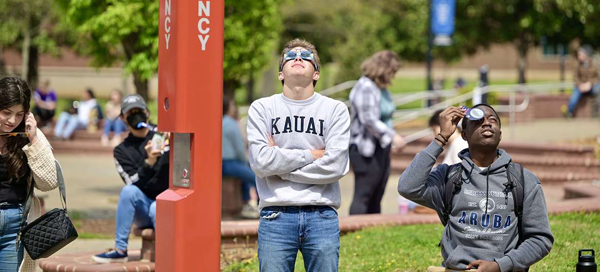 Wearing protective eclipse glasses, Middle Tennessee State University students gaze into the sky Monday, April 8, in the MTSU Quad area near the James E. Walker Library on the campus in Murfreesboro, Tenn., checking out the solar eclipse that brought 93% totality to the local area. (MTSU photo by Andy Heidt)