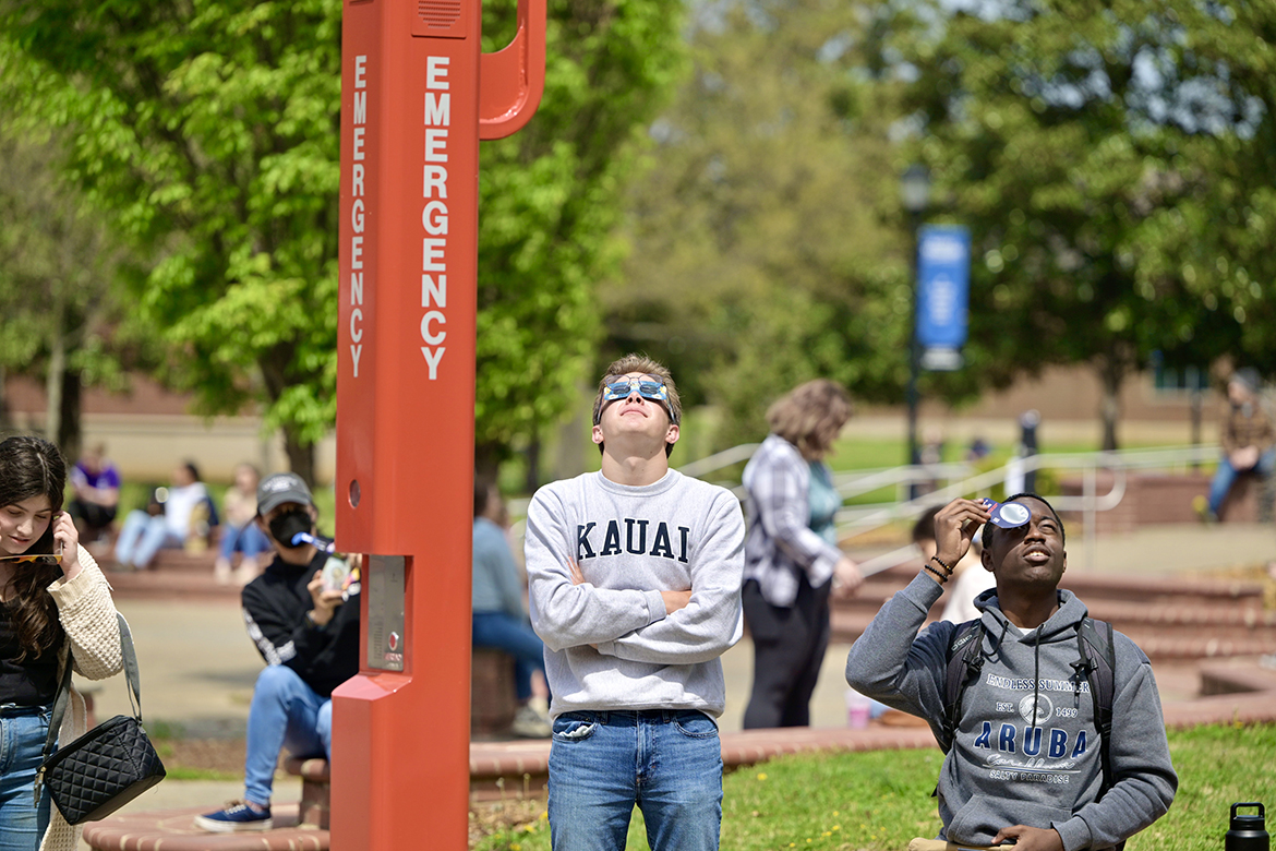 Wearing protective eclipse glasses, Middle Tennessee State University students gaze into the sky Monday, April 8, in the MTSU Quad area near the James E. Walker Library on the campus in Murfreesboro, Tenn., checking out the solar eclipse that brought 93% totality to the local area. (MTSU photo by Andy Heidt)