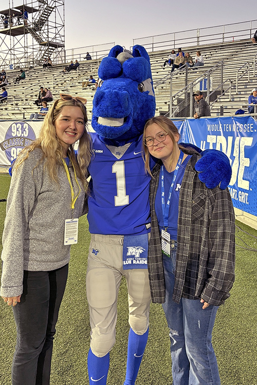 Middle Tennessee State University senior journalism major Maddy Williams, left, poses for a photo with mascot Lightning and fellow journalism major Jordan Reining at Floyd Stadium on the MTSU campus in Murfreesboro, Tenn. Williams, who creates social media content for the Division of Marketing and Communications and is social media manager for the student digital publication Sidelines, is scheduled to graduate in August, almost a year earlier than normal, thanks to the dual enrollment classes she took while in high school. (Photo submitted)
