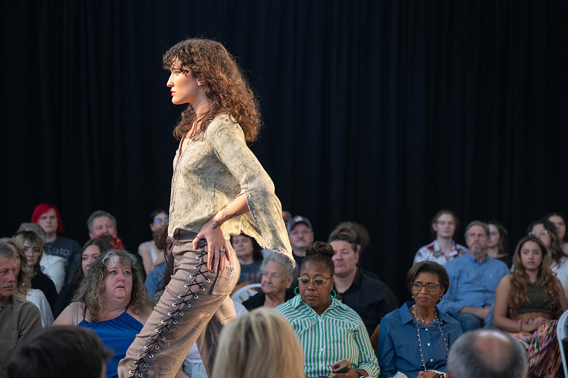 As the crowd looks on, Skye Bendheim models an outfit at Middle Tennessee State University's 2024 Textiles, Merchandising and Design Runway Show held Saturday, April 20, at Miller Education Center in Murfreesboro, Tenn. (MTSU photo by Cat Curtis Murphy)