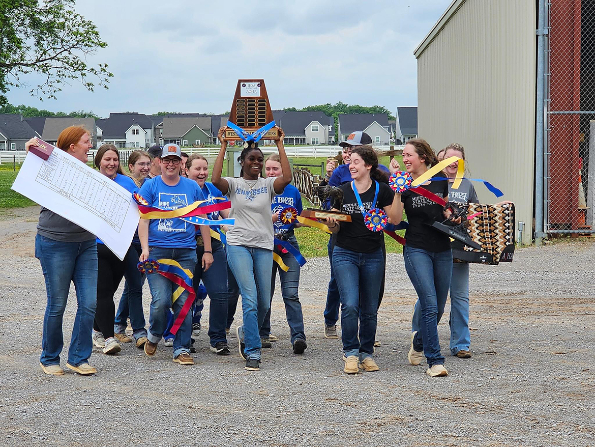 As Sadio Barnes, center, carries the national championship trophy, Middle Tennessee State University coaches Ariel Higgins, left, and Andrea Rego and Western discipline team members return to the Horse Science Center on Thompson Lane in Murfreesboro, Tenn., with other awards, celebrating their second consecutive Intercollegiate Horse Show Association title. Team members include Jordan Martin, Mackenzie Latimer, Simone Allen, Sadio Barnes, Monica Braunwalder, Kenlee West, Louann Braunwalder, Regan Black, Shelby Amanns and Alyssa Davis. (Submitted photo)