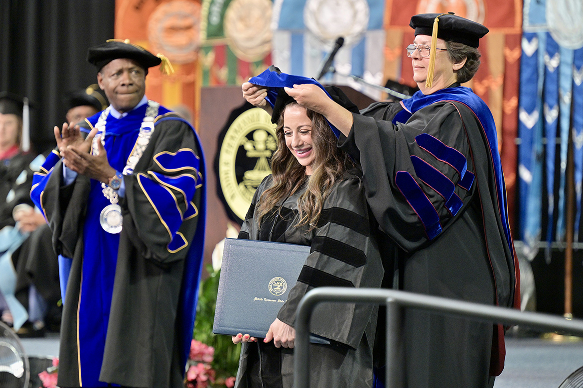 Middle Tennessee State University doctoral candidate Lauren Michelle Blade, who earned her Ph.D. in English, is hooded by professor Rhonda McDaniel at the Friday, May 3, commencement ceremony at Murphy Center in Murfreesboro, Tenn. It was the first of three ceremonies Friday and Saturday, May 4, to celebrate the total 2,439 graduates for the spring Class of 2024. (MTSU photo by J. Intintoli)