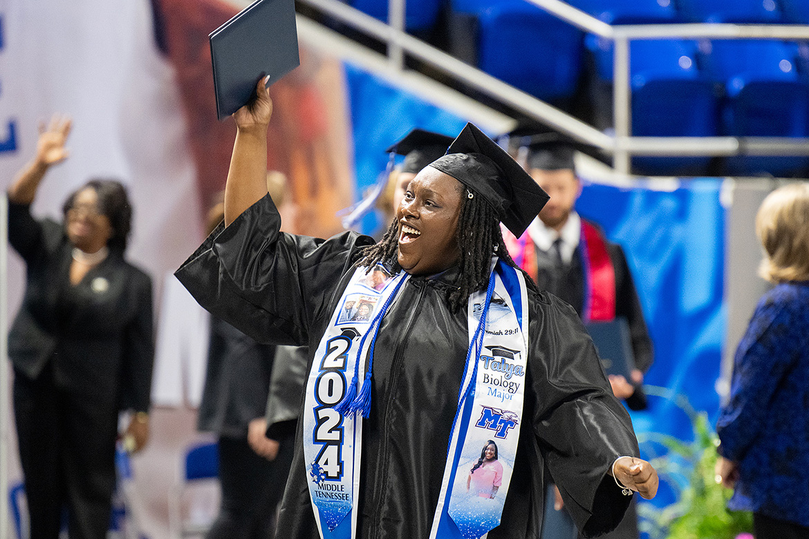 Middle Tennessee State University spring 2024 graduate Talya Alexus Mccullough, who earned her undergraduate degree in biology, proudly lifts her diploma toward supporters during the Saturday, May 4, morning commencement ceremony at Murphy Center in Murfreesboro, Tenn. (MTSU photo by Cat Curtis Murphy)