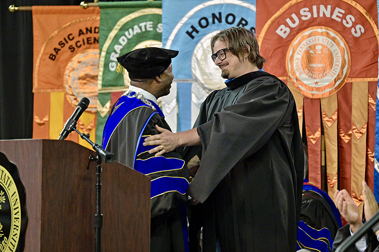 Middle Tennessee State University President Sidney A. McPhee, left, thanks singer-songwriter and alumnus Michael Hardy, who performs professionally as HARDY, following his keynote remarks at the Saturday, May 4, afternoon spring commencement ceremony at Murphy Center in Murfreesboro, Tenn. It was the last of three ceremonies May 3-4. (MTSU photo by Andy Heidt)