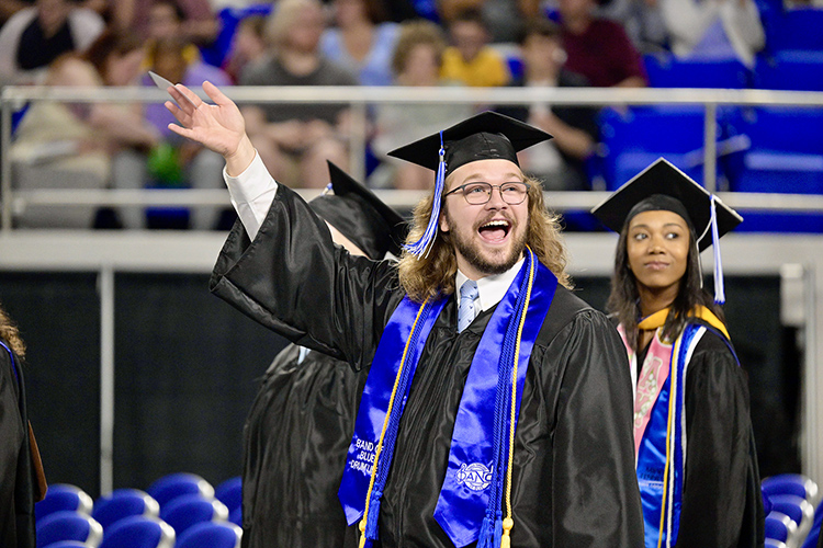 A proud Middle Tennessee State University graduate and Band of Blue member waves to supporters during the Saturday, May 4, afternoon spring commencement ceremony at Murphy Center in Murfreesboro, Tenn. It was the last of three ceremonies May 3-4. (MTSU photo by Andy Heidt)