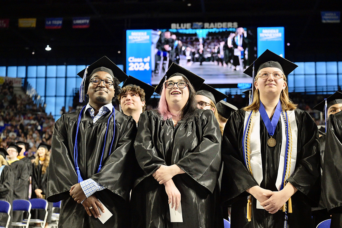 Middle Tennessee State University graduates watch the commencement procession on the jumbotron during the Saturday, May 4, afternoon spring commencement ceremony at Murphy Center in Murfreesboro, Tenn. It was the last of three ceremonies May 3-4. (MTSU photo by Andy Heidt)