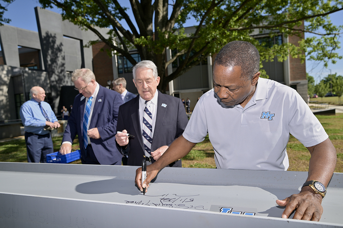 As Middle Tennessee State University alumnus Donald McDonald waits his turn, President Sidney A. McPhee, signs the final steel beam that was later placed on top of the new MTSU Applied Engineering Building Wednesday, May 1, on the southeast side of campus in Murfreesboro, Tenn. Construction is moving ahead on the 90,000-square-foot, $74.8 million building that is scheduled to open by the start of the fall 2025 academic semester. (MTSU photo by J. Intintoli)