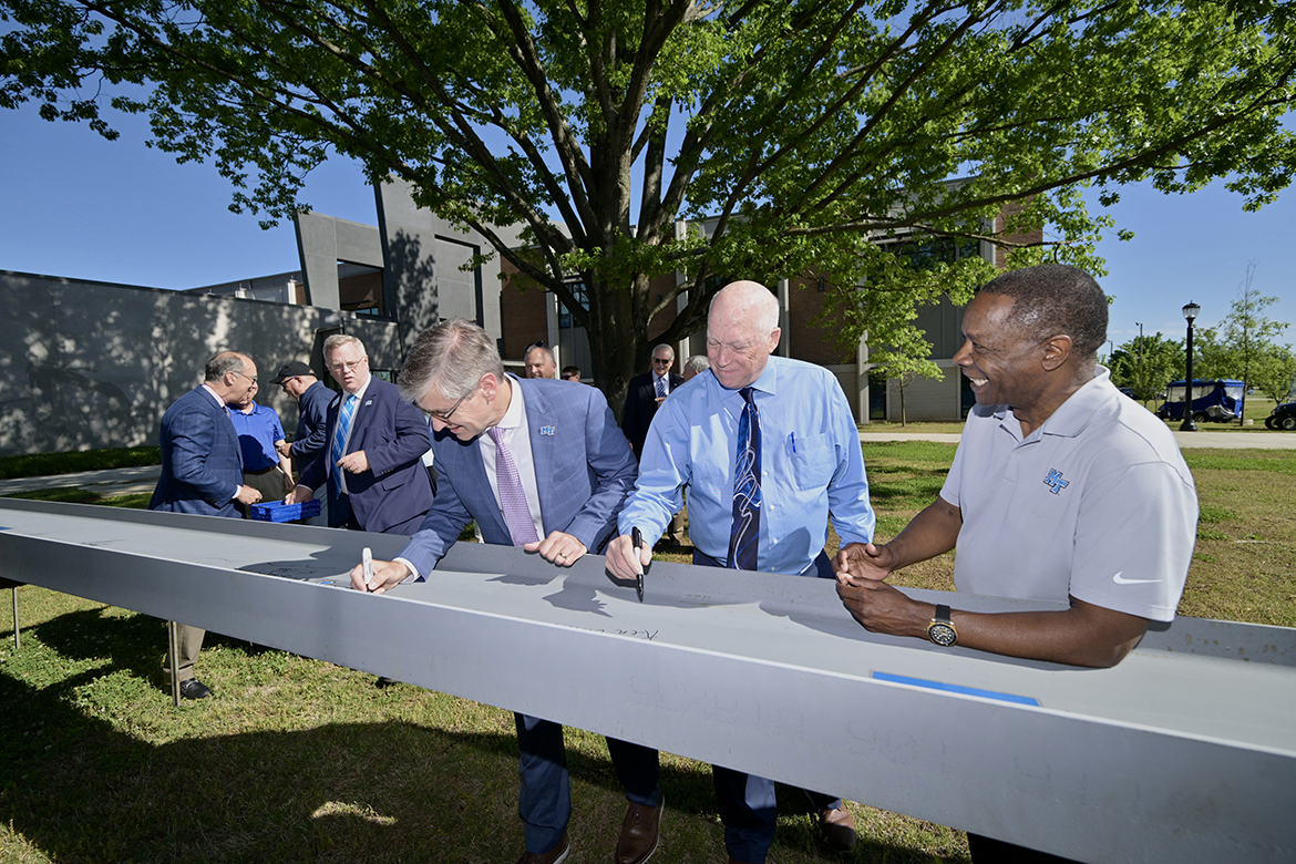 Middle Tennessee State University College of Basic and Applied Sciences Dean Greg Van Patten, left, and Engineering Technology Chair Ken Currie sign the final steel beam as MTSU President Sidney A. McPhee smiles in the brief Applied Engineering Building topping out ceremony Wednesday, May 1, next to the School of Concrete and Construction Management Building on the MTSU campus in Murfreesboro, Tenn. The building will house the renowned Mechatronics Engineering program and other Engineering Technology concentrations. (MTSU photo by J. Intintoli)
