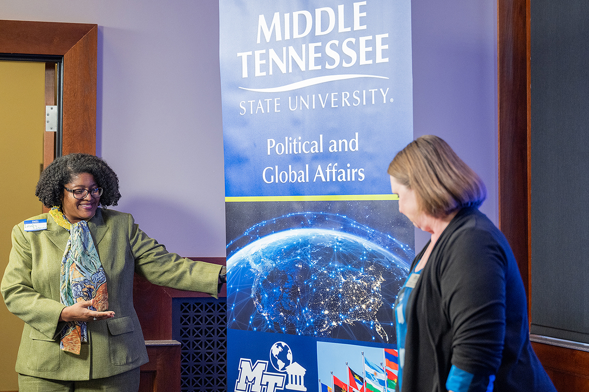 Middle Tennessee State University College of Liberal Arts Dean Leah Lyons, left, points to the new Department of Political and Global Affairs sign during an unveiling ceremony at the Spring Alumni Showcase held April 9, 2024, at the MT Center on campus in Murfreesboro, Tenn. Looking on is department chair and political science professor Amy Atchison. (MTSU photo by Cat Curtis Murphy)