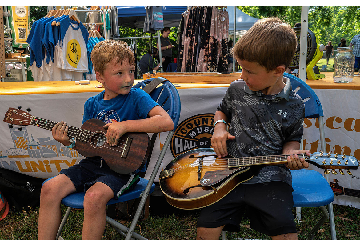 Young attendees play stringed instruments in the Family String Band Circle area of the annual “Roots on the Rivers” music festival in Nashville, Tenn. The annual fundraiser benefitting Middle Tennessee State University's WMOT-FM Roots Radio 89.5 allows attendees to participate in the music and try out various instruments. (Photo courtesy of John Partipilo/WMOT)